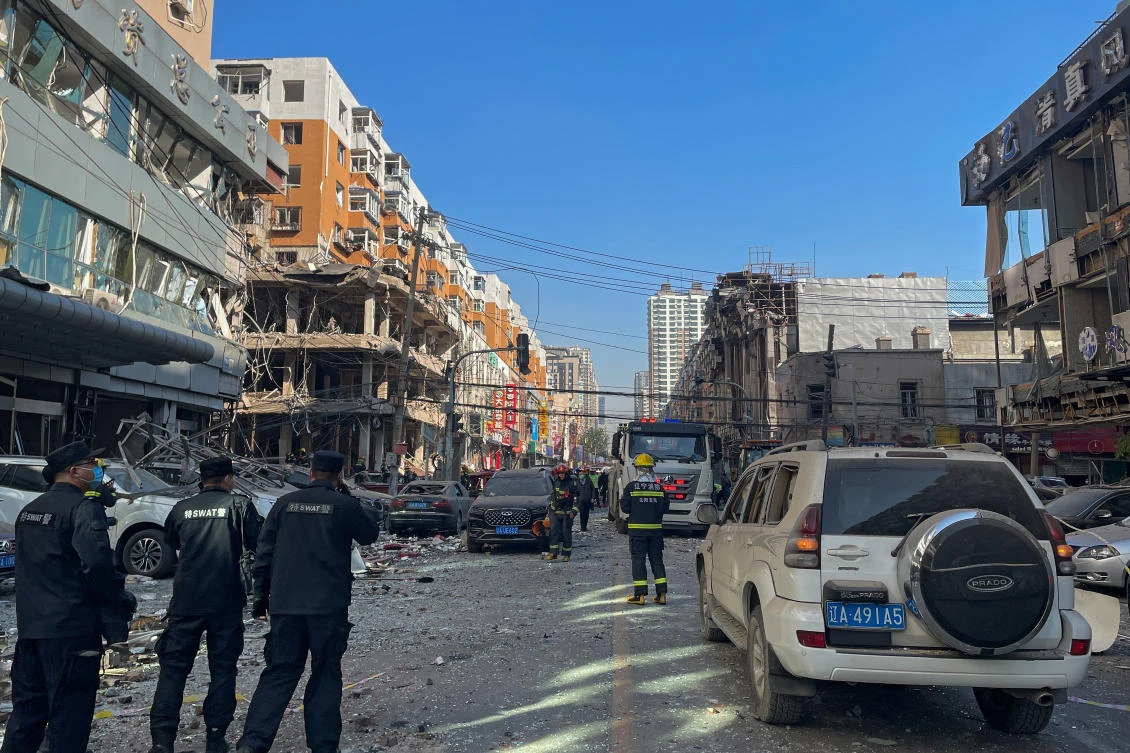 In this photo released by Xinhua News Agency, policemen and firefighters walk through damaged shophouses following an explosion in Shenyang in northeastern China’s Liaoning Province, Thursday, Oct. 21, 2021. (AP)