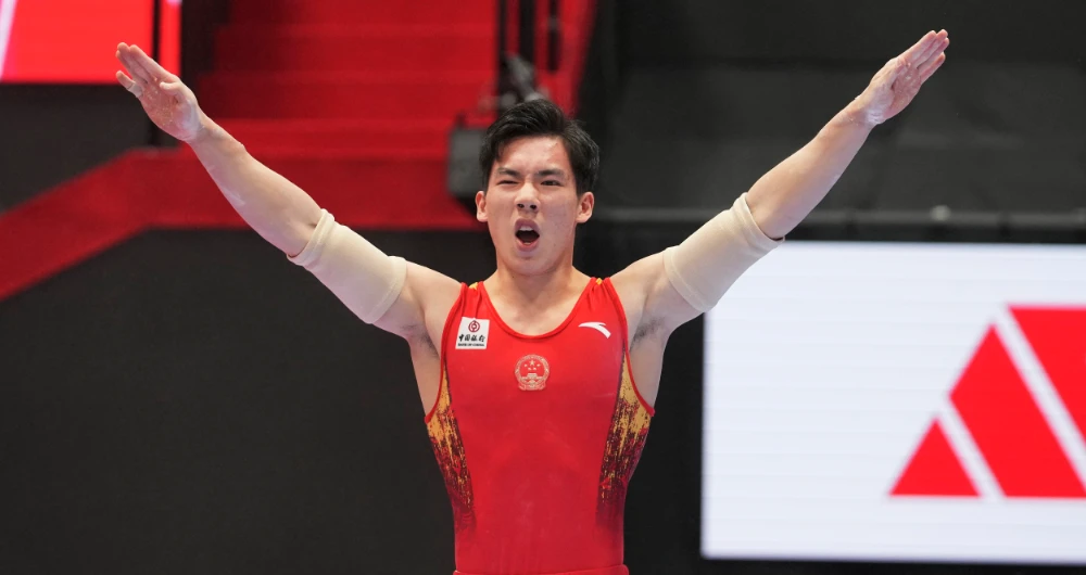 Zhang Boheng, of China, poses as he finishes the parallel bars during the men's all-around finals in the FIG Artistic Gymnastics World Championships in Kitakyushu, western Japan, Friday, Oct. 22, 2021. (AP)