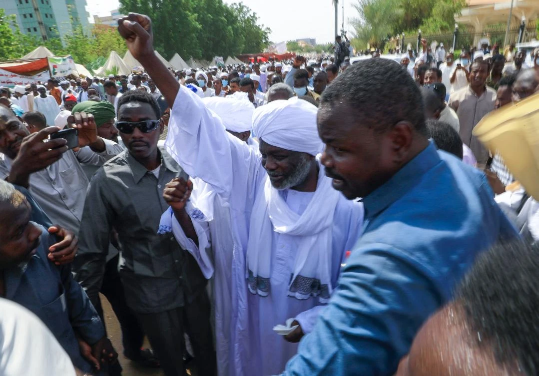 Sudanese Minister of Finance Gibril Ibrahim raises his fist as he attends Friday prayers alongside pro-military protesters, in front of the presidential palace in the capital Khartoum on Friday. (AFP)