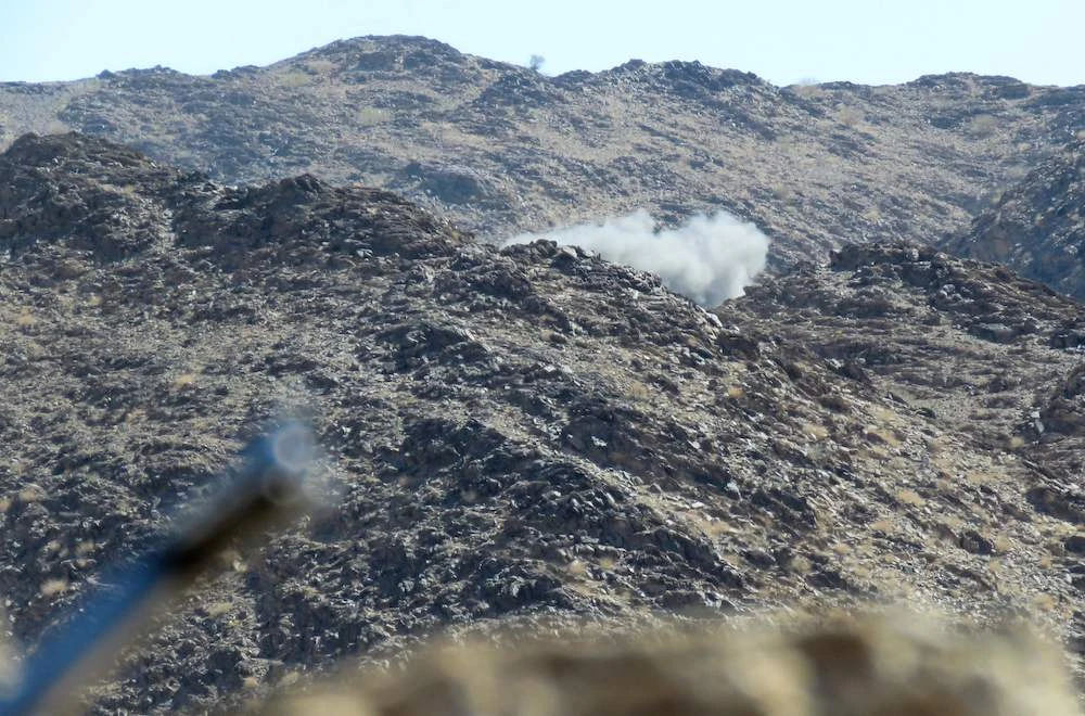 Fighters loyal to the Yemeni government man positions as smoke billows at the Al-Juba frontline, facing the Houthi militia in the northeastern province of Marib, on Oct. 24, 2021. (AFP)