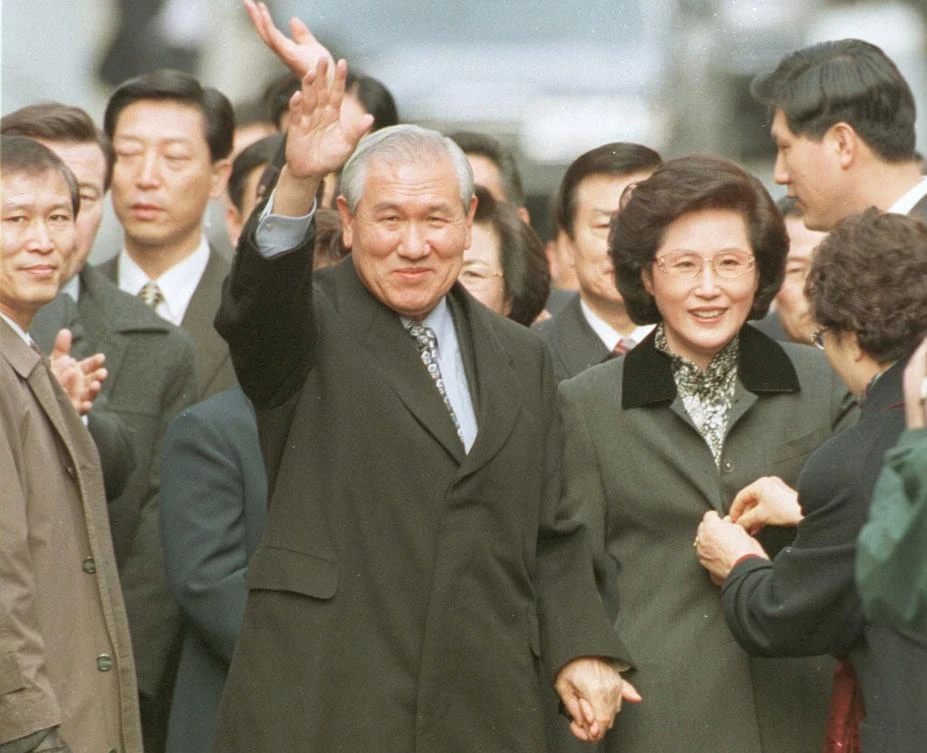 In this Dec. 22, 1997, file photo former South Korean President Roh Tae-woo, with his wife Kim Ok-sook standing beside him, waves to his supporters and neighbors. (AP)