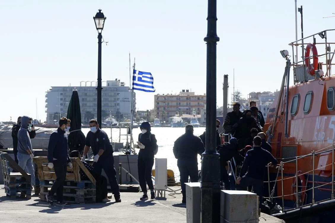 Migrants disembark from a coast guard vessel after an operation near the northeastern Aegean island of Chios, Greece, Tuesday, Oct. 26, 2021. (AP Photo)