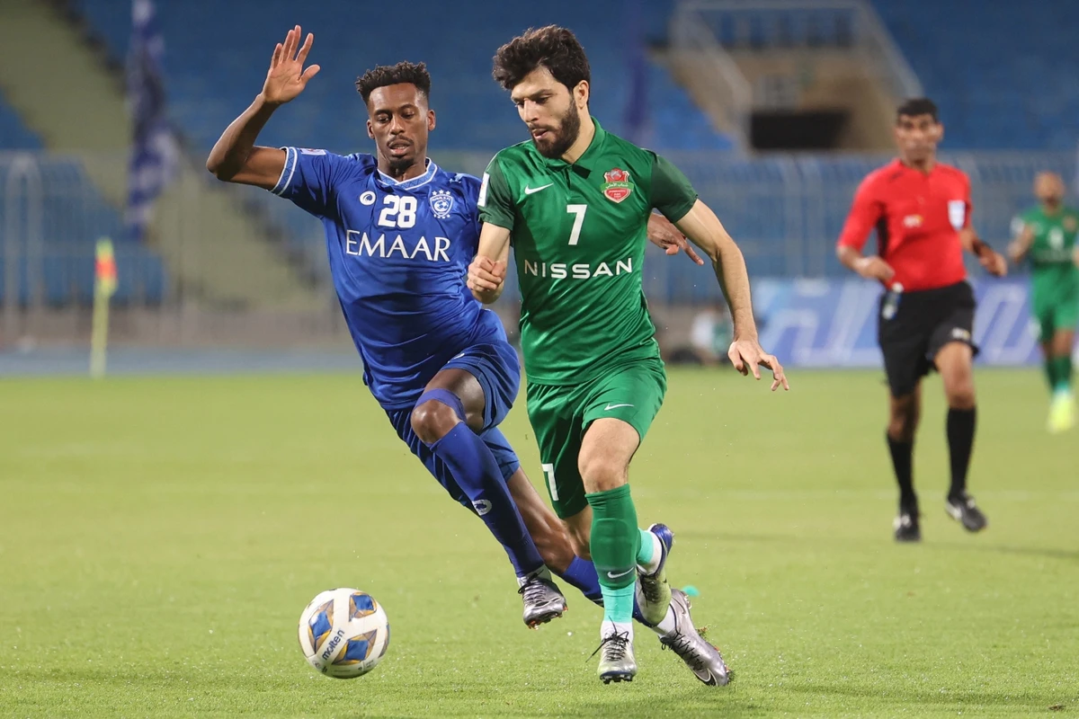 Hilal's midfielder Mohamed Kanno (L) marks Shabab's midfielder Jaloliddin Masharipov during the AFC Champions League group A match between Saudi's Al-Hilal and UAE's Shabab Al-Ahli on April 30, 2021. (File/AFP)