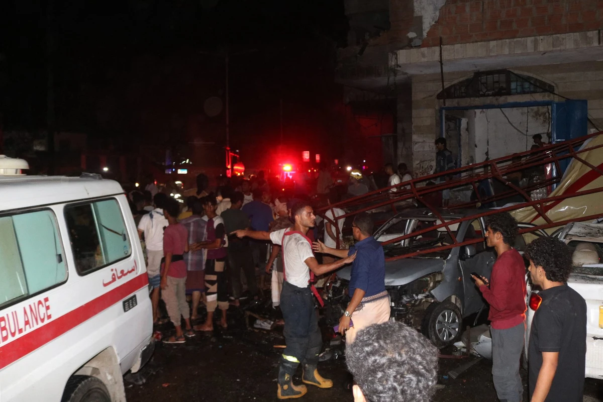Yemeni emergency service staff and bystanders gather at the site of a blast near the airport of the southern city of Aden, on October 30, 2021. (AFP)