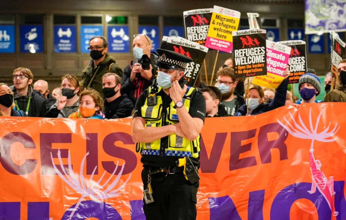 Climate activists hold banners at Glasgow Central station in Glasgow, Scotland ahead of the start of COP26, Saturday, Oct. 30, 2021. (AP)