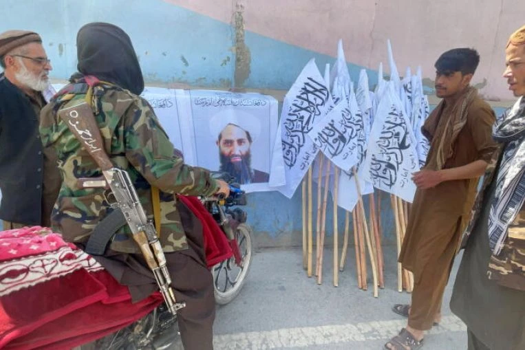 Members of Taliban forces gather and look at a picture of the movement's leader, Haibatullah Akhundzada, in Kabul , Afghanistan, on Aug. 25. (Reuters/File)