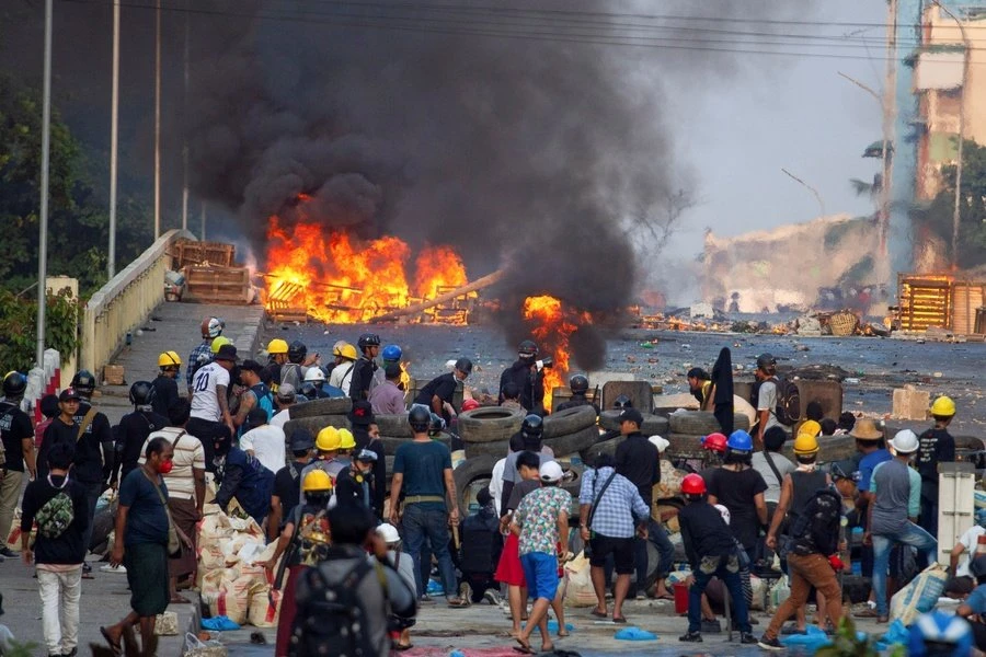 Anti-coup protesters man a barricade as they clash with security forces on Bayint Naung Bridge, Mayangone, Yangon, Myanmar, Mar. 16, 2021. (Reuters)