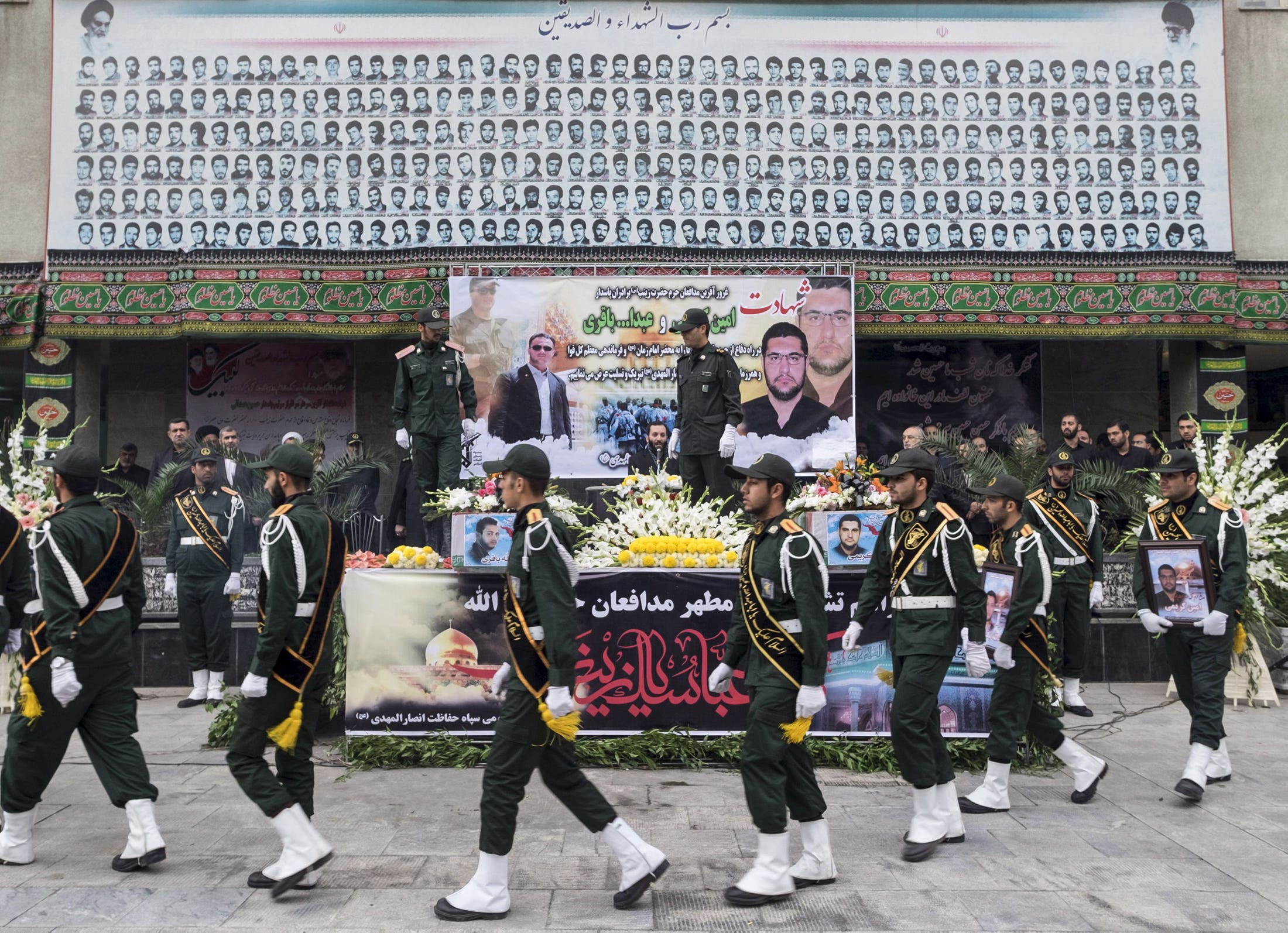 Iranian soldiers walk past the coffins of two members of the Iranian Revolutionary Guards, who were killed in Syria. (Reuters)