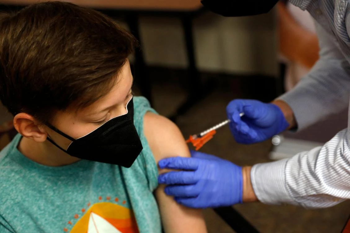 In this file photo taken on May 13, 2021 Aiden Arthurs receives the Pfizer-BioNTech Covid-19 Vaccine from Pharmacist Andrew Mac (R) at the Jewish Federation/JARC’s offices in Bloomfield Hills, Michigan. (AFP)