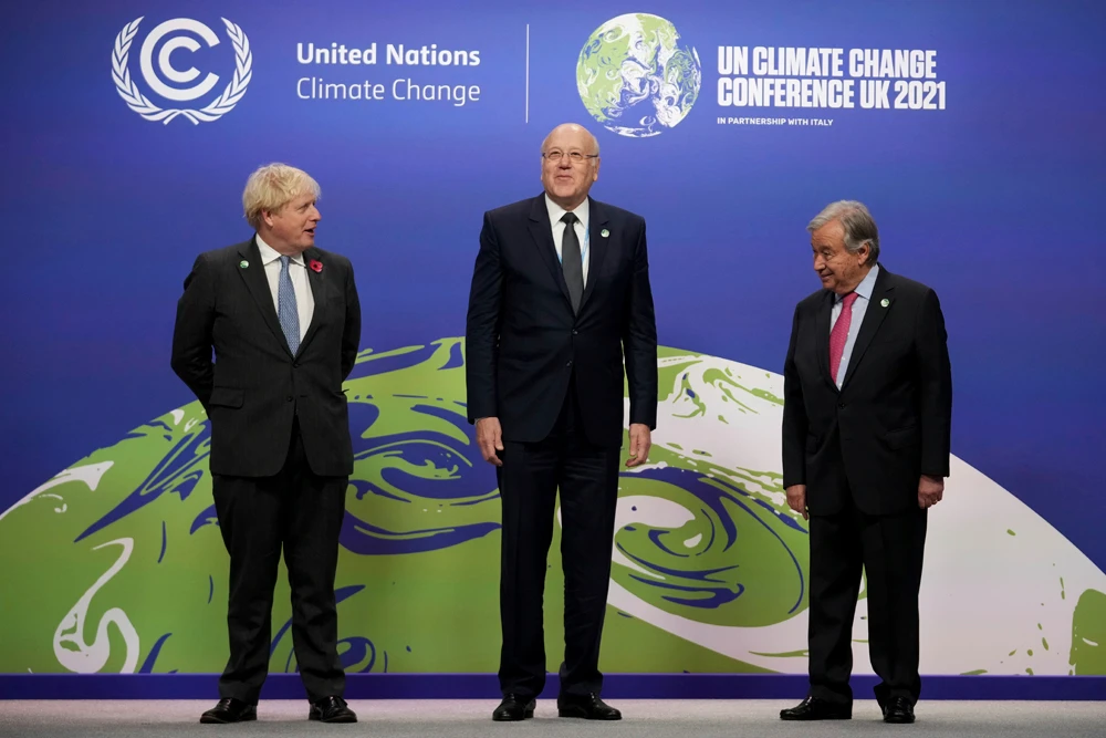 British PM Boris Johnson, left, and UN Secretary-General Antonio Guterres, right, greet Lebanese PM Najib Mikati at the COP26 UN Climate Summit in Glasgow, Scotland, Nov. 1, 2021. (AP Photo)