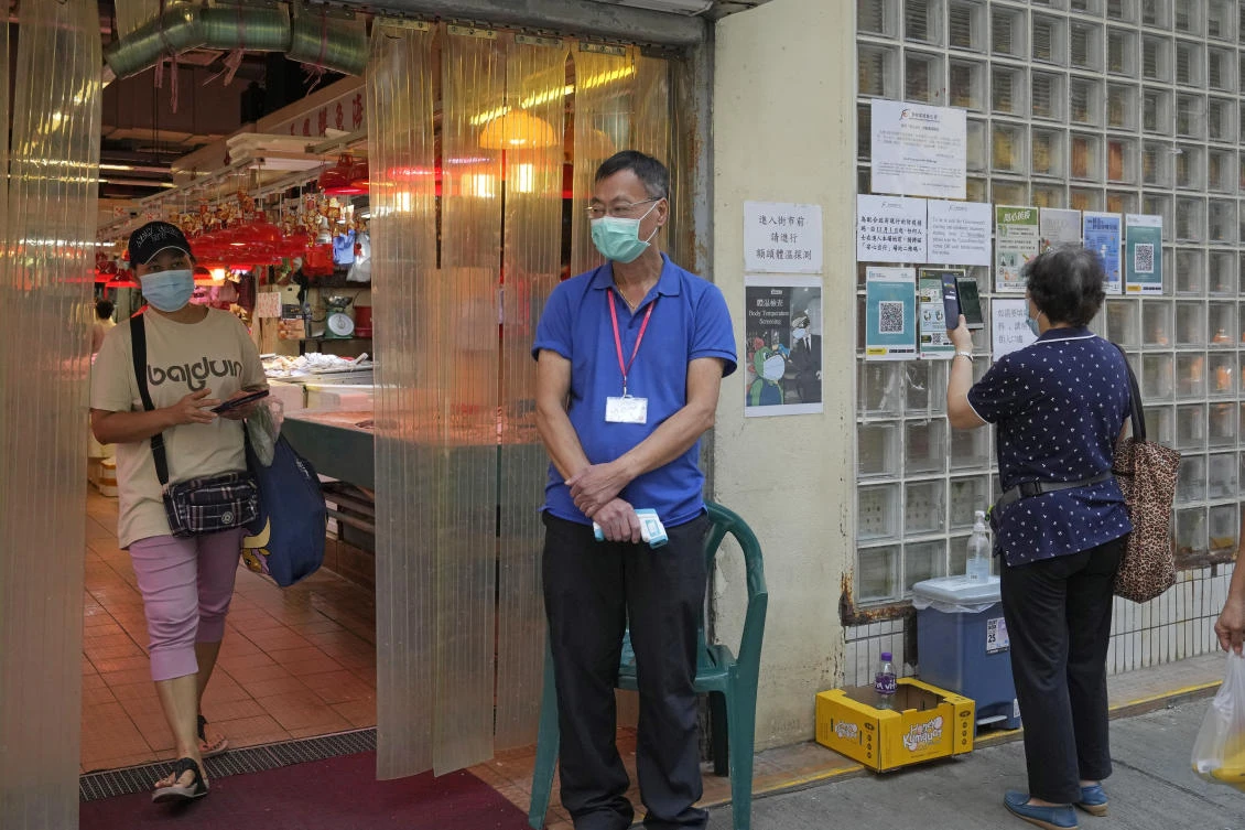 A resident scans the government’s contact tracing QR code for the ‘LeaveHomeSafe’ COVID-19 mobile app before entering a market in Hong Kong on Nov. 2, 2021. (AP)
