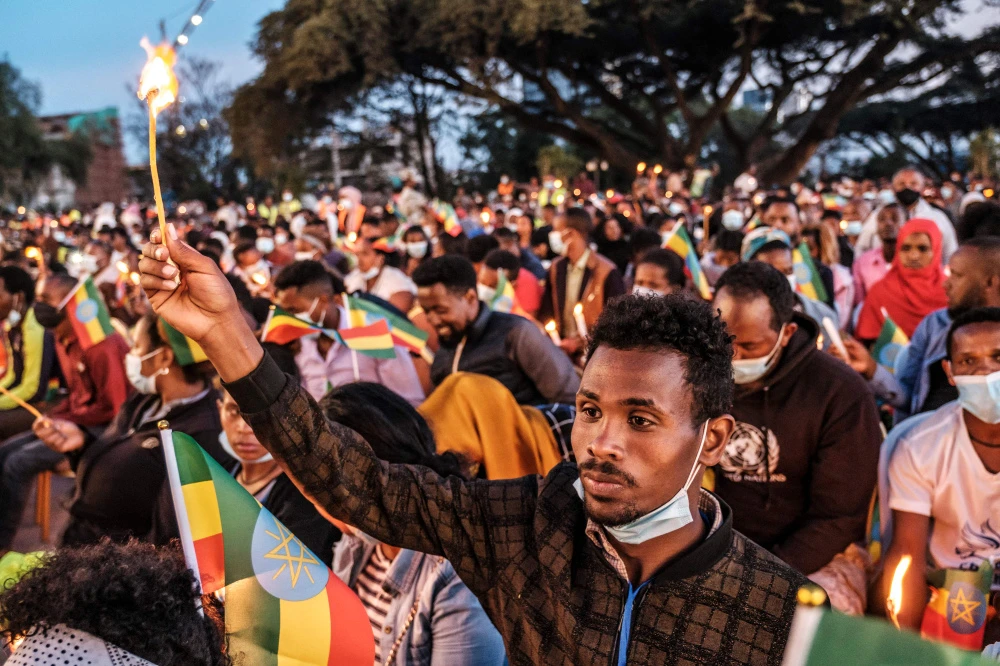 A man holds a candle during a memorial service in Addis Ababa for the victims of Ethiopia’s Tigray conflict. (AFP)