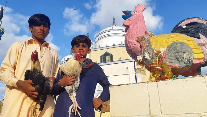 Boys hold roosters at Saman Sarkar’s shrine in Badin, in Pakistan's southern Sindh province, before releasing the birds during celebrations on October 22, 2021. (AN photo by Zulfiqar Kunbhar)