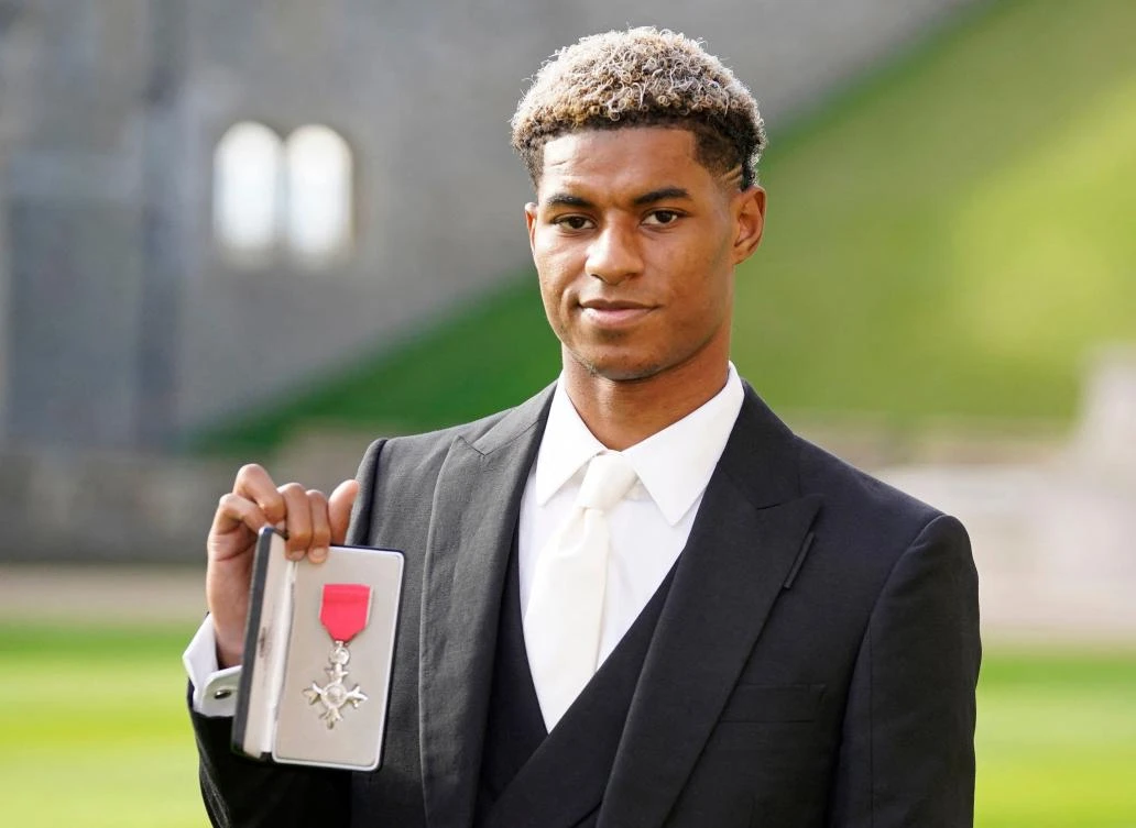 Manchester United and England footballer Marcus Rashford poses with his medal after being appointed a Member of the Order of the British Empire for services to Vulnerable Children in the UK during Covid-19 on Tuesday. (AFP)
