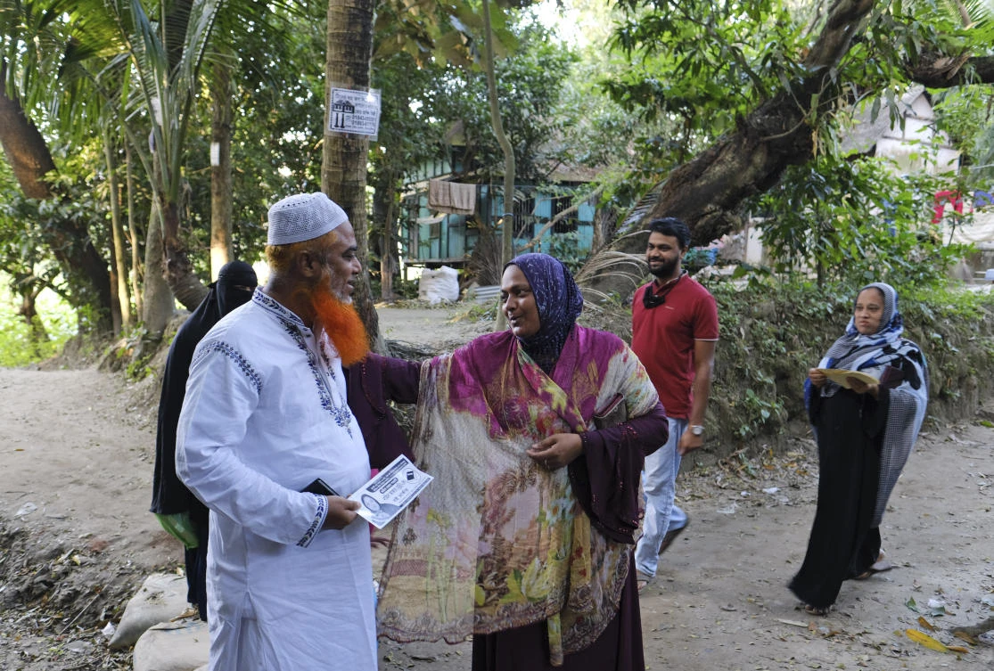 Independent candidate Nahida Akhter Munni, front right, distributes a leaflet to a voter during an election campaign for the local government election in Srinagar, Munshiganj district, Bangladesh, Friday, Nov. 5, 2021. (AP)