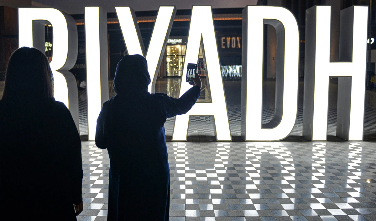A woman uses her phone to take a picture of a lit "I LOVE RIYADH" sign at a shopping centre in Saudi Arabia's capital Riyadh on October 31, 2020. (AFP/ File)