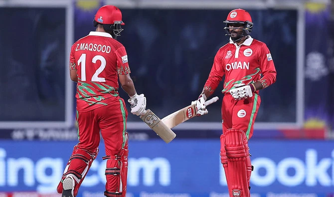 Oman's Sandeep Goud, right, and teammate captain Zeeshan Maqsood touch their bats during the ICC men's Twenty20 World Cup cricket match between Oman and Scotland at the Oman Cricket Academy Ground in Muscat on October 21, 2021. (AFP/File)