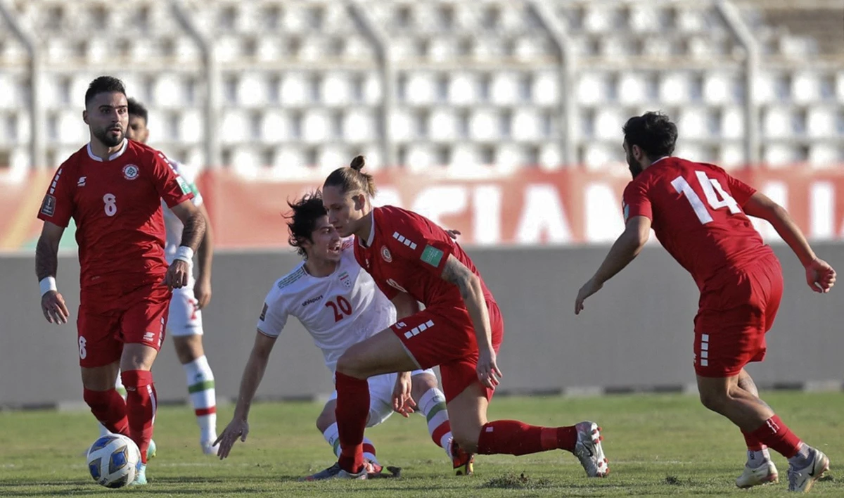 Iran's forward Sardar Azmoun vies for the ball with Lebanon's forward Hassan Saad and midfielder George Felix during their World Cup Qatar 2022 qualifying match at Saida Stadium in Lebanon on Thursday. (AFP)
