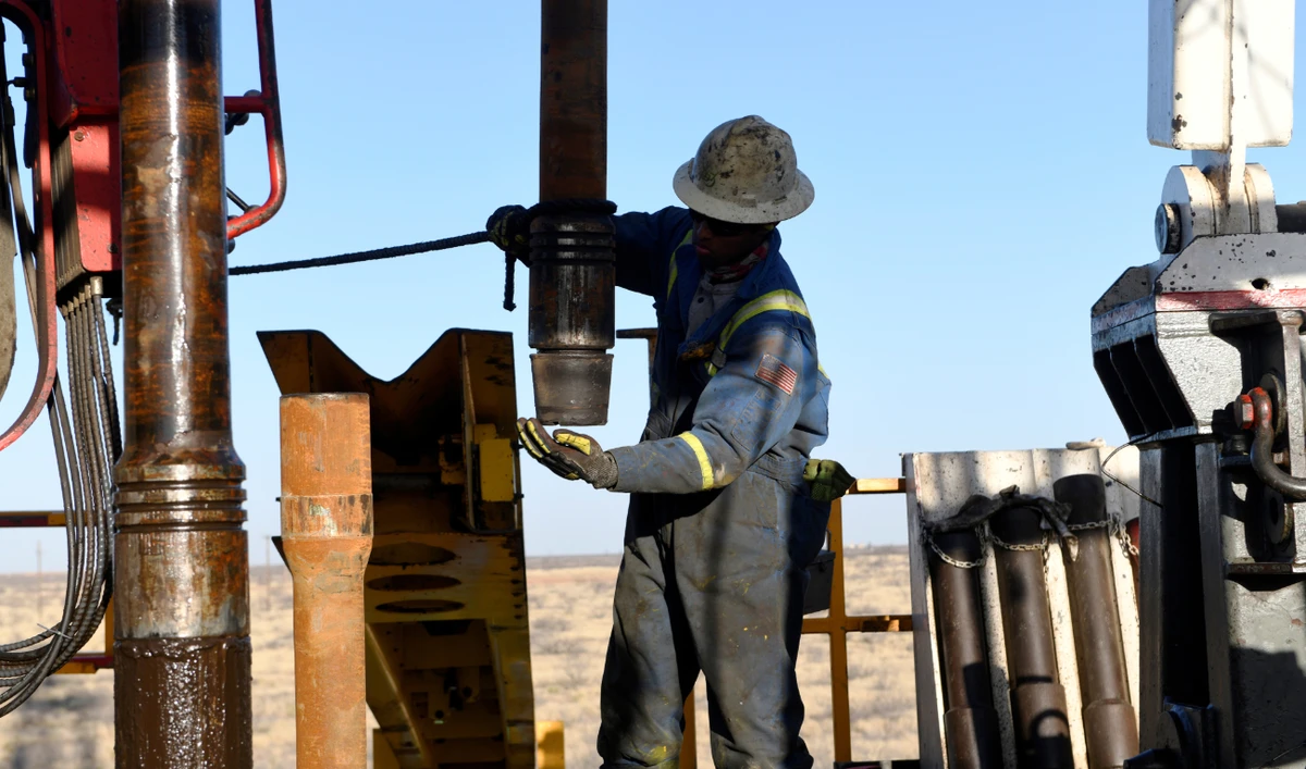 An oil worker removes a thread cap from a piece of drill pipe on a drilling lease owned by Elevation Resources near Midland, Texas, US. (Reuters/File)