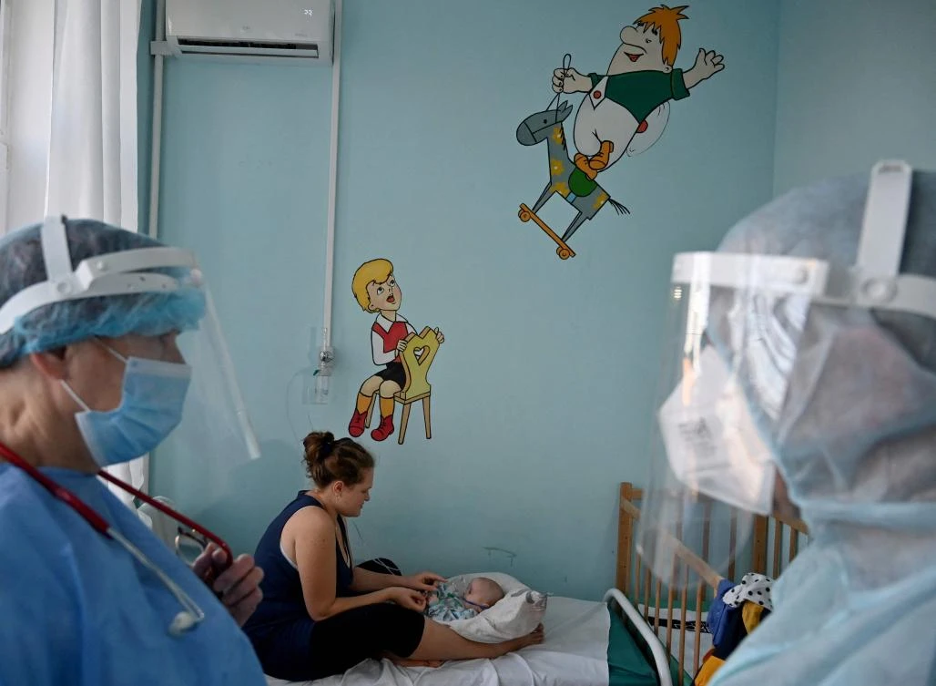 A woman holds an oxygen mask over the face of her baby suffering from Covid-19 in a ward of the children’s hospital in Kiev on Tuesday. (AFP)