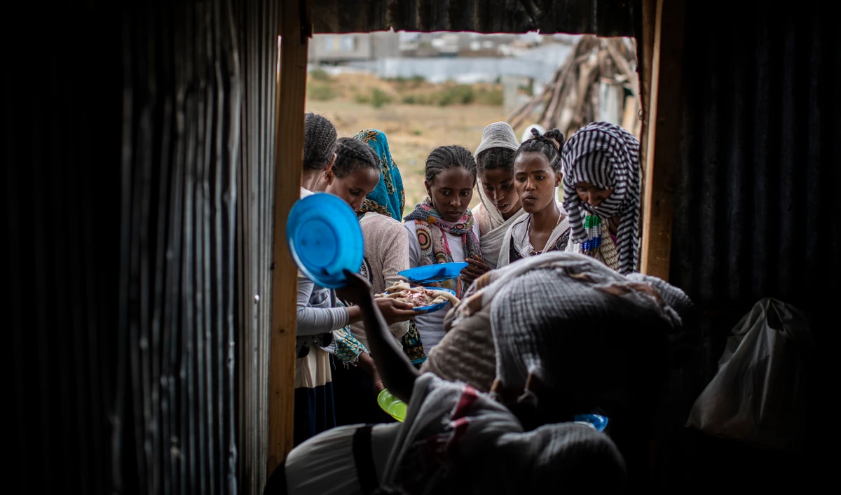 Tigrayans stand in line to receive food donated by local residents at a reception center for the internally displaced in Mekele. (AP)