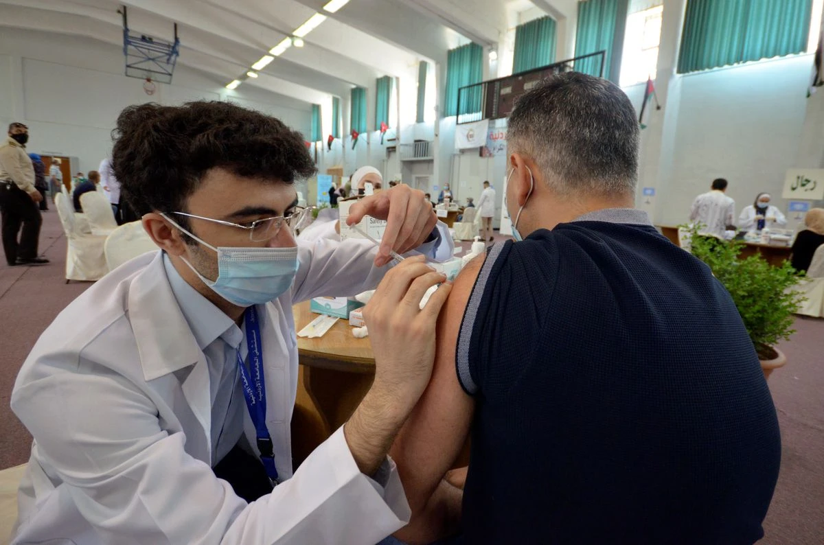A medical worker administers the coronavirus disease (COVID-19) vaccine to a man in Amman, Jordan. (File/Reuters)