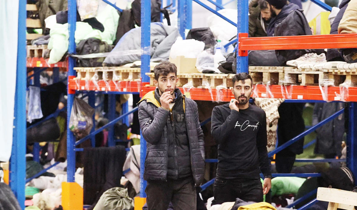 Migrants stay in the transport and logistics center in freezing conditions near the Bruzgi border point on the Belarusian-Polish border in the Grodno region. (AFP)