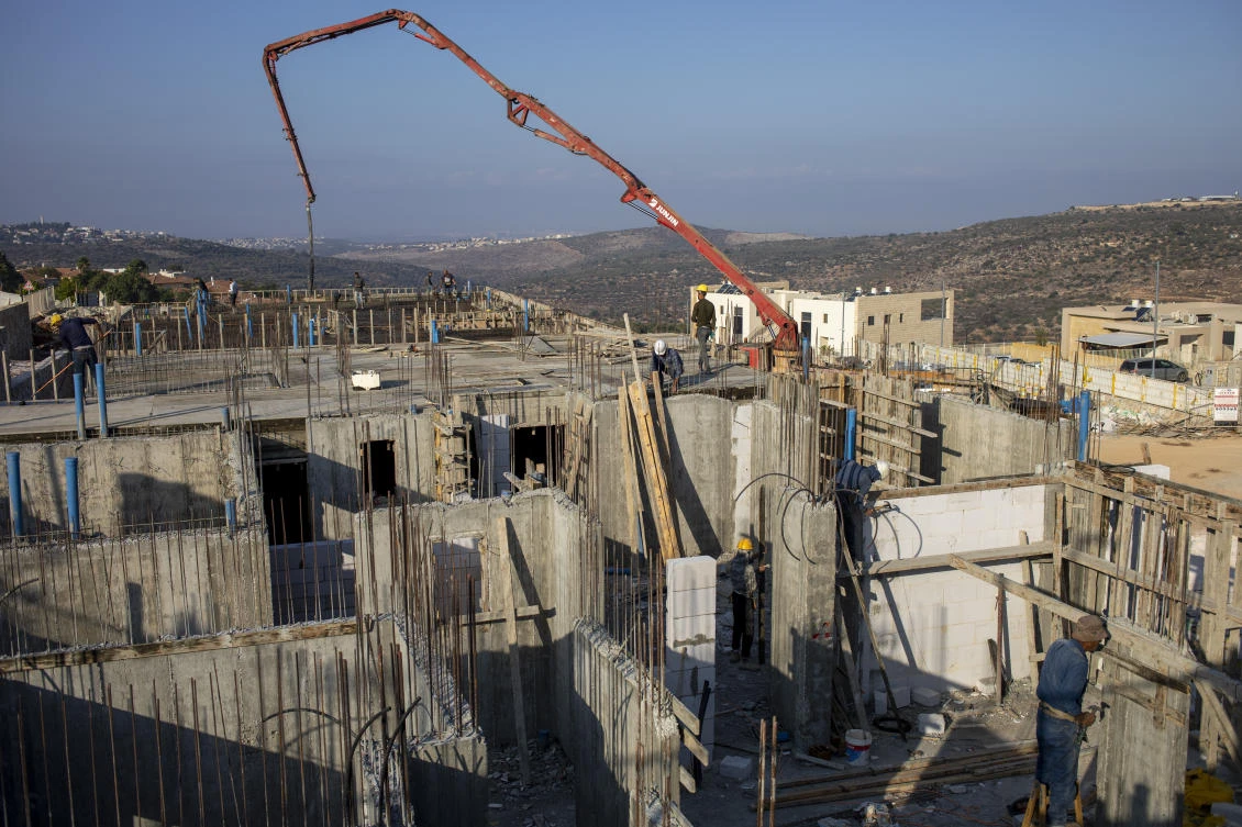 Palestinian laborers work building new houses in the West Bank Jewish settlement of Bruchin near the Palestinian town of Nablus, Monday, Oct. 25, 2021. (File/AP)