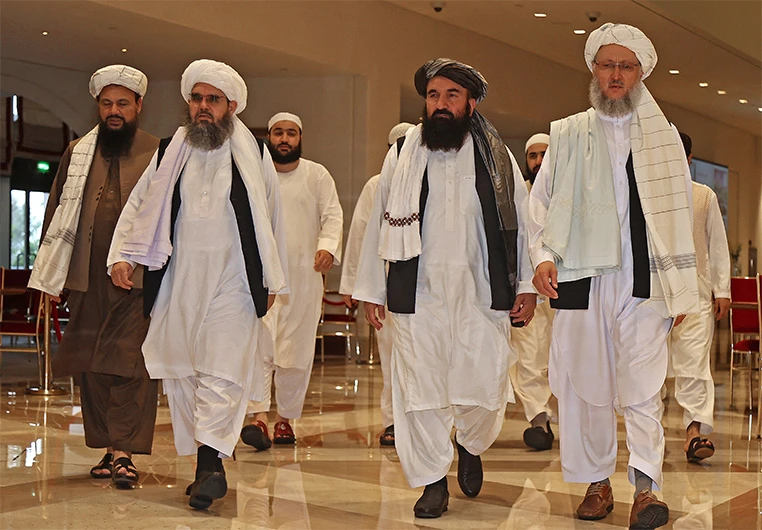 Head of the Taliban delegation Abdul Salam Hanafi (R), accompanied by Taliban officials (2R to L) Muttaqi, Shahabuddin Delawar and Abdul Latif Mansour, walks down a hotel lobby in Qatar's capital Doha on August 12, 2021. (AFP/FILE)
