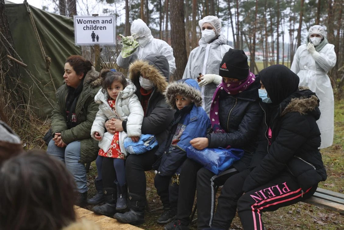 Migrants wait for an appointment with a Belarusian doctor near a logistics center at the checkpoint “Kuznitsa” at the Belarus-Poland border near Grodno, Belarus, on Wednesday. (AP)
