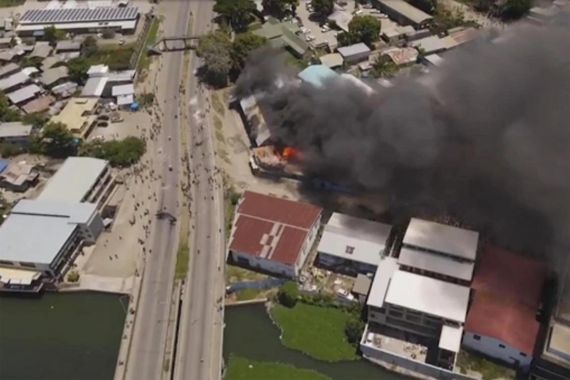Protesters breached the National Parliament building, burned the thatched roof of a nearby building, and set fire to a police station and other buildings. (Australian Broadcasting Corporation via AP)
