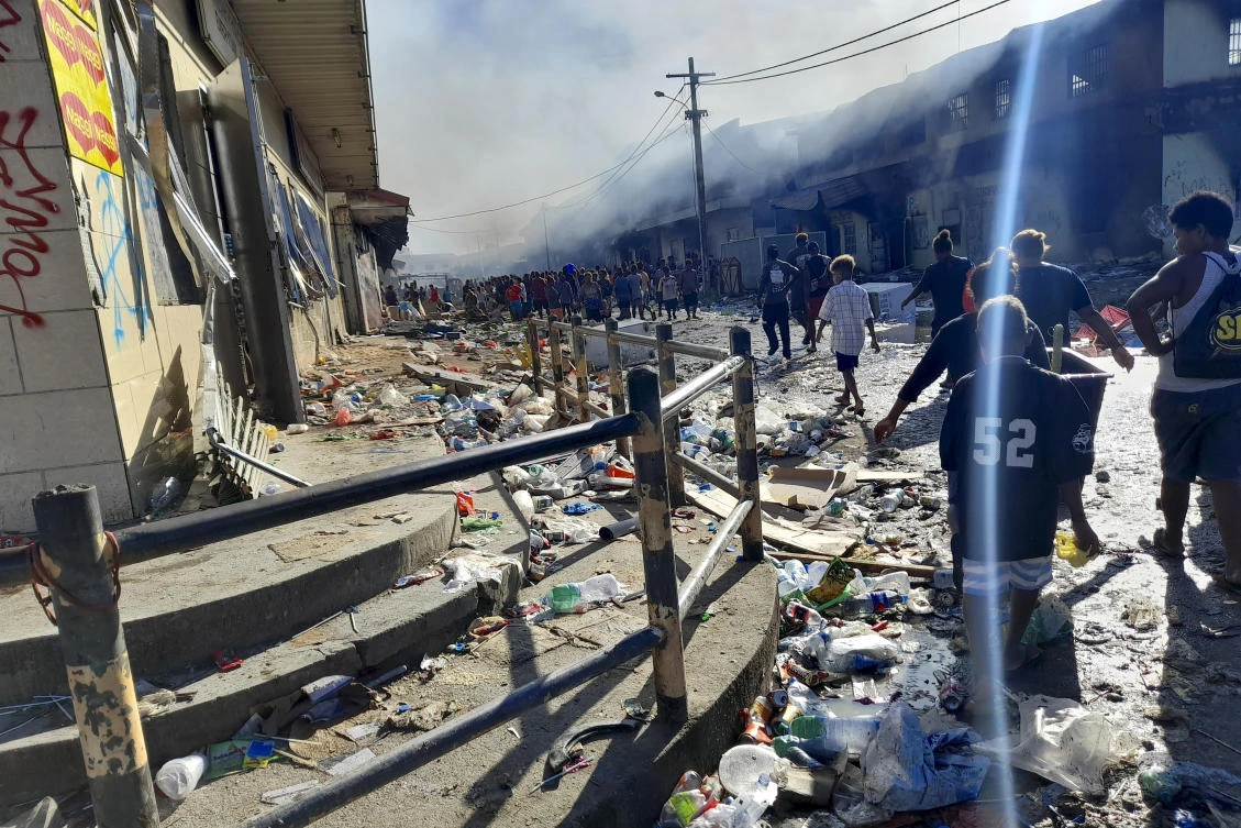 Residents walk through the looted streets of Chinatown in Honiara, Solomon Islands on Nov. 26, 2021. (AP)