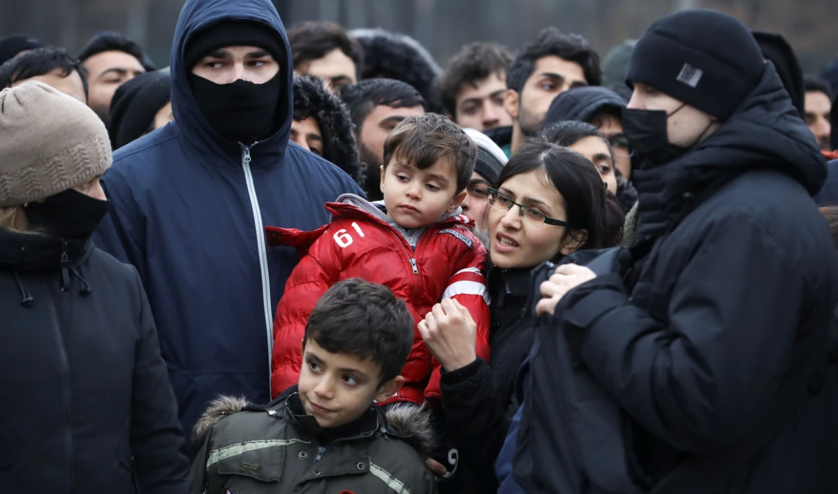Migrants gather on Friday to listen to an address by Belarusian President Alexander Lukashenko during his visit to the Belarusian-Polish border. (Reuters)