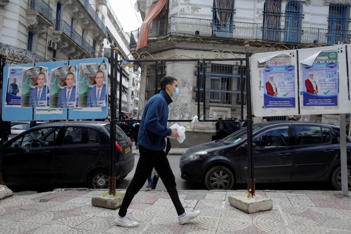 A person walks past election campaign posters, ahead of the local elections, in Algiers, Algeria November 25, 2021. (Reuters)