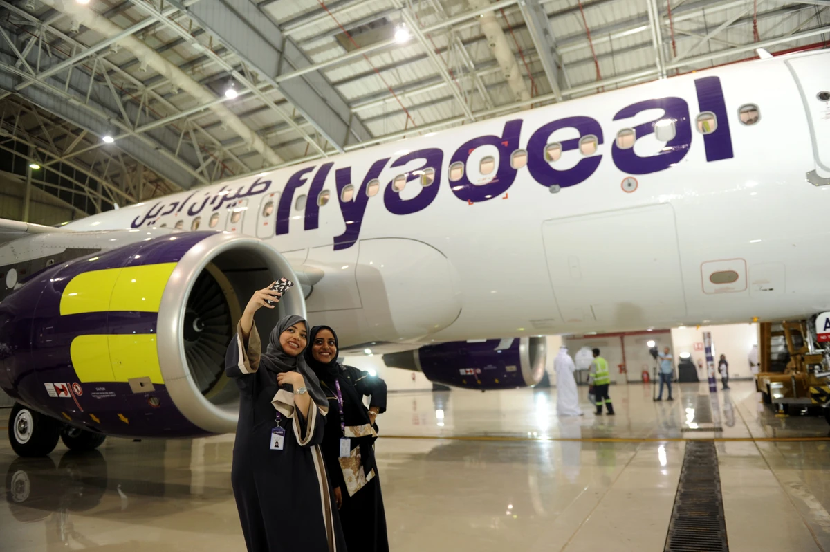 Saudi employees of flyadeal take a selfie in front of an aircraft at the King Abdulaziz airport in Jeddah. It now operates six routes to the UAE on a daily basis — with the other five originating from Riyadh. GettyImages