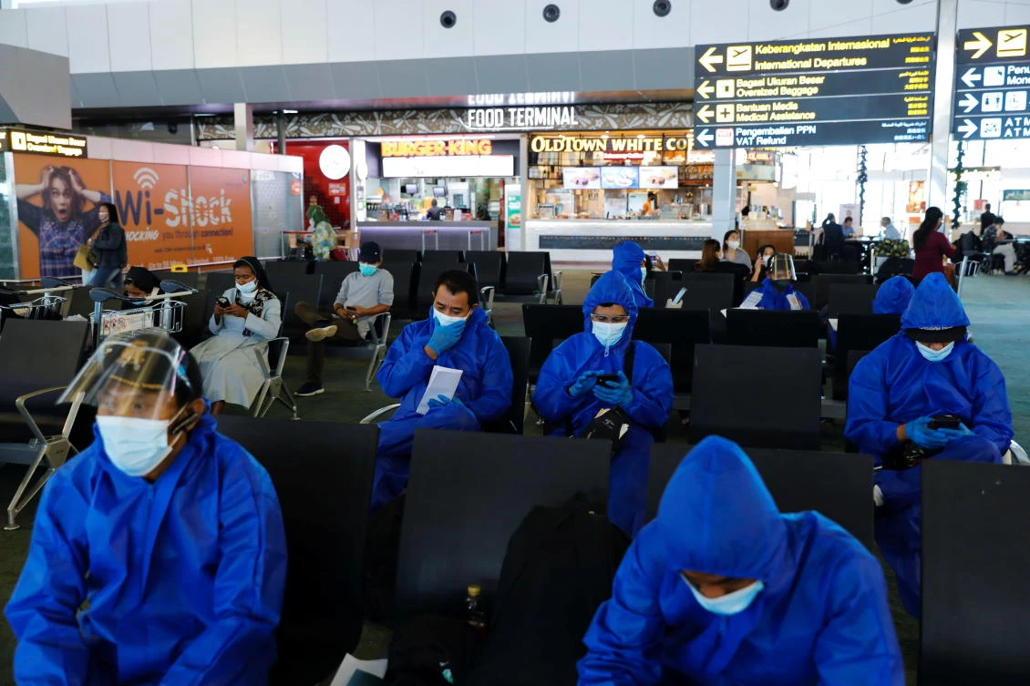 Travelers wearing protective suits at Soekarno Hatta International airport as the country bans the arrival of travelers from 8 eight African countries to curb Omicron variant of Covid-19 from spreading in Jakarta, Indonesia on Monday. (Reuters)