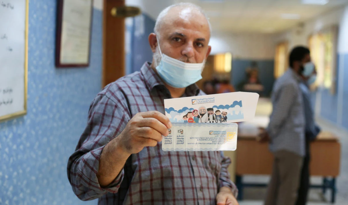 Man shows his voter card inside the polling station in Tripoli. (REUTERS/FILE)