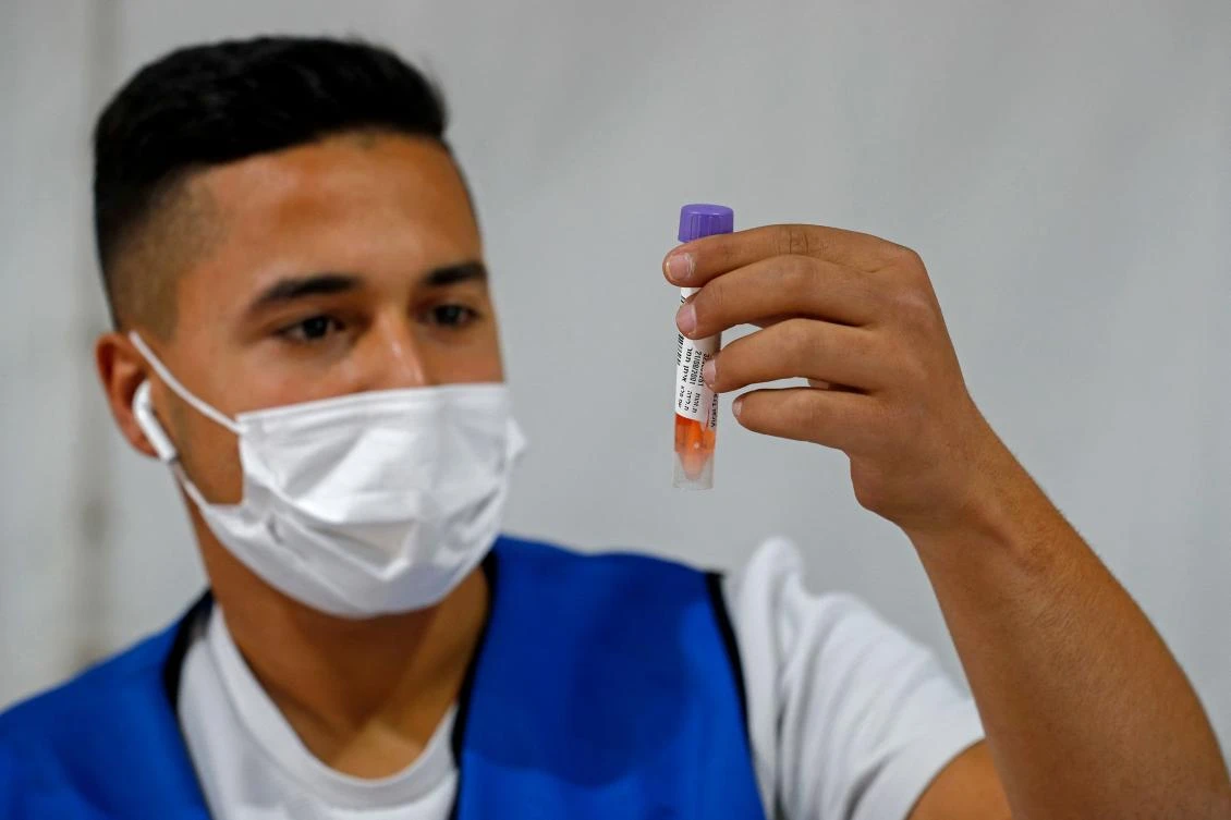 A medic collects a swab sample at a Covid-19 drive-through testing site in Jerusalem on November 29, 2021. (AFP)