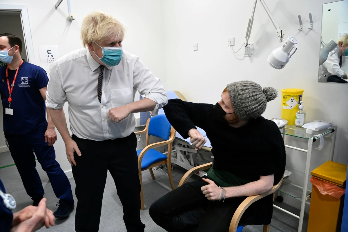 Boris Johnson bumps elbows with a patient receiving a COVID-19 vaccine during his visit to the Lordship Lane Primary in London, Tuesday, Nov. 30, 2021. (AP)