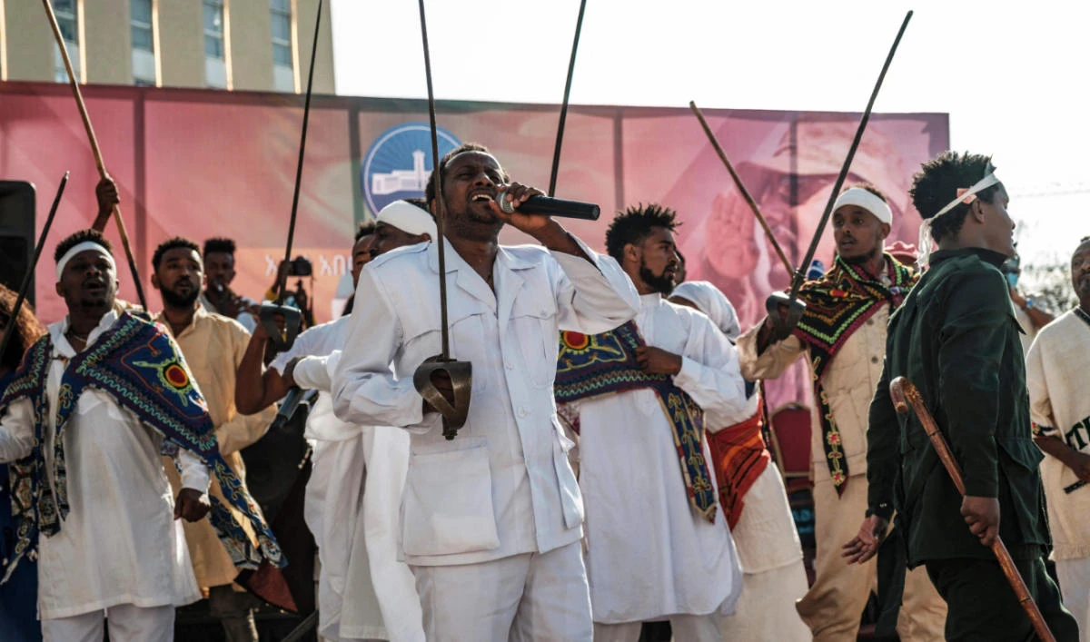 Men in traditional clothes sing and dance holding swords during a rally bringing together artists and athletes headed to visit troops on the front line, in Addis Ababa. (AFP)