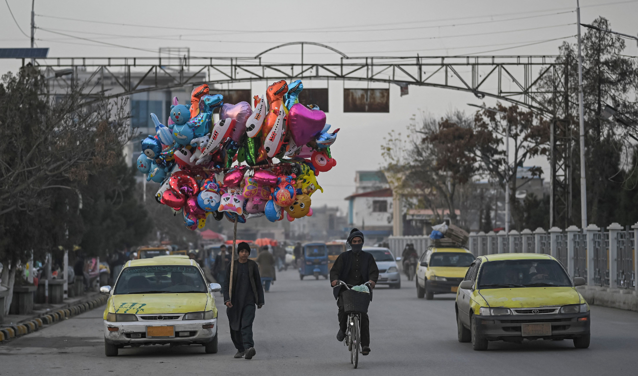 An Afghan youth sells balloons on a street in Mazar-i-Sharif on December 23, 2021. (AFP)