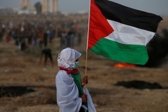 A woman holds a Palestinian flag during a Great March of Return protest at the Israel-Gaza border fence, Gaza Strip, Oct. 19, 2018. (Reuters)
