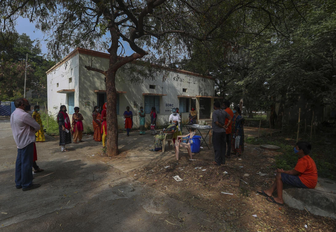 A health worker takes a nasal swab sample of a woman as others wait to get tested for COVID-19 in Hyderabad, India, Thursday, Dec. 2, 2021. (AP)