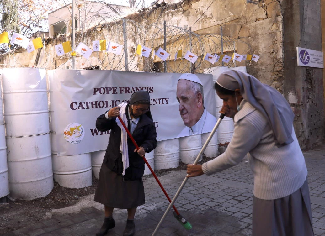Nuns clean the road in front of the Holy Cross Catholic Church, where Pope Francis is to conduct an ecumenical prayer for migrants, next to the UN Buffer Zone in Nicosia on Thursday. (Reuters)