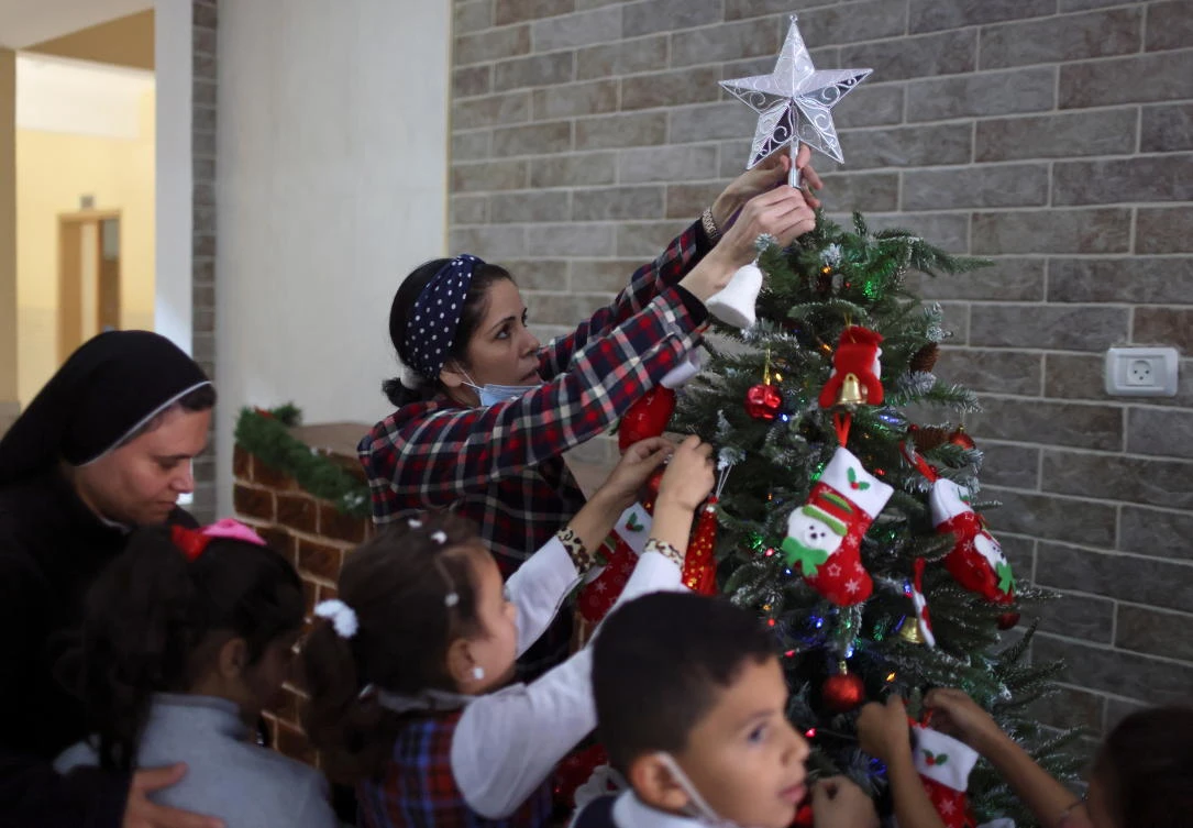 A teacher decorates a Christmas tree with students at Rosary Sisters’ School in Gaza City, last week. (Reuters)