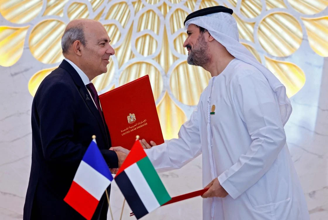 CEO of Dassault Aviation Éric Trappier (L) shakes hands with an Emirati official after the signing of a deal to buy French Rafale jetfighters in Dubai on December 3, 2021. (AFP)