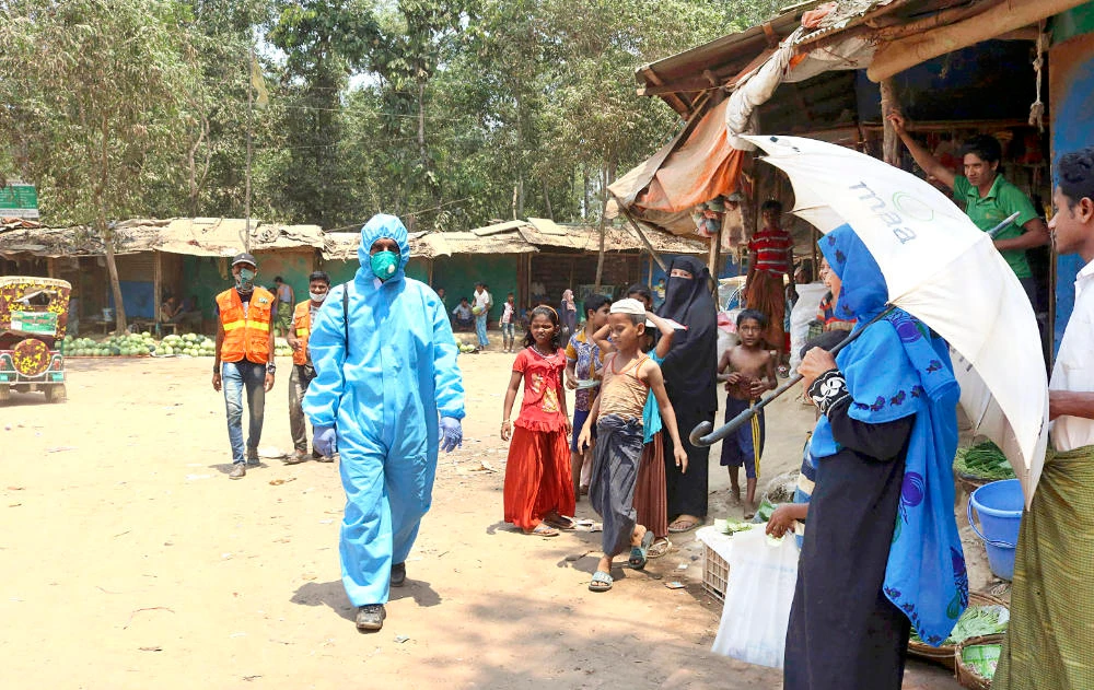 A health worker along with locals at the Kutupalong Rohingya refugee camp in Cox’s Bazar. Bangladesh hosts more than 1.1 million Rohingya. (AP/File)