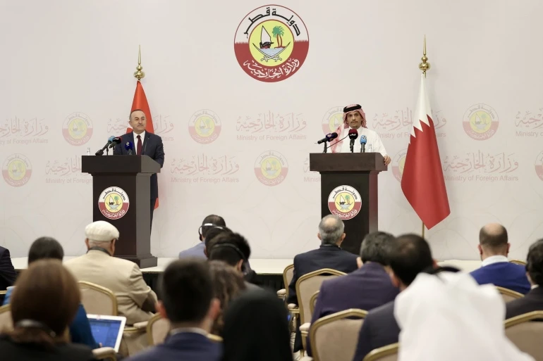 Turkish FM Mevlut Cavusoglu, left, and Qatari FM Sheikh Mohammed bin Abdulrahman Al-Thani hold a joint press conference following their meeting in Doha, Dec. 6, 2021. (Getty Images)