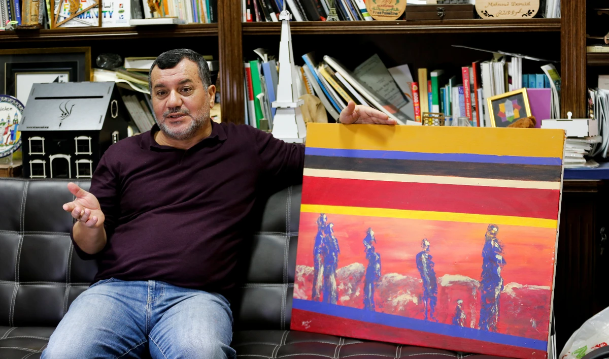 Palestinian Abdelfattah Abusrour shows his painting at his office in Aida refugee camp, Bethlehem, in the Israeli-occupied West Bank. (Reuters)