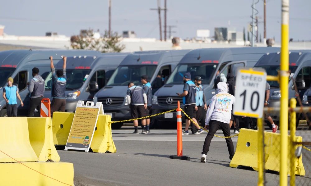 Amazon drivers cheer as they go back to their their delivery vans, as their logistics systems is announced to be back online at the Amazon Delivery Station in Rosemead, Calif., Tuesday, Dec. 7, 2021. (AP)